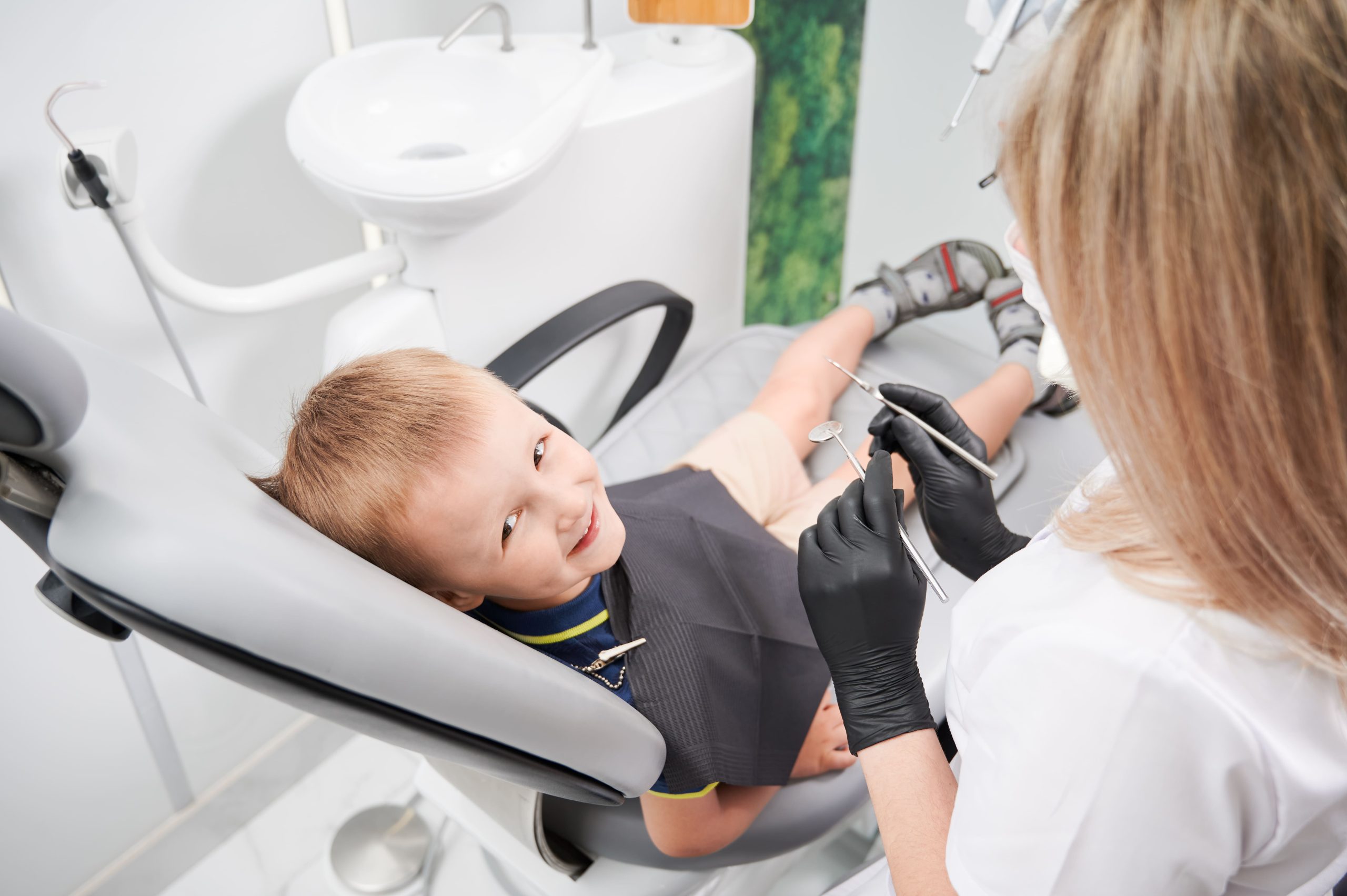 nino-alegre-sentado-en-una-silla-dental-en-el-consultorio-dental